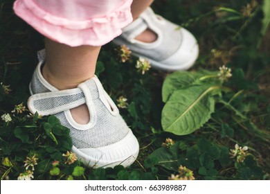 Baby In White Sandals In Grass