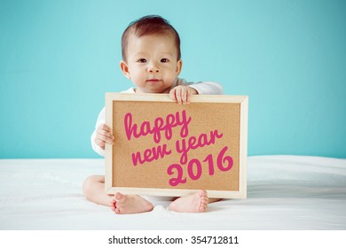 Baby writing Happy New Year 2016 on the board, new family concept