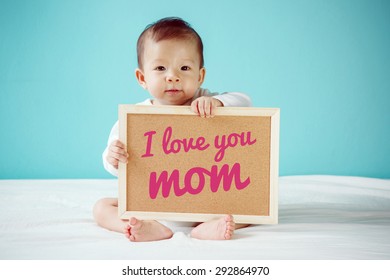 Baby writing "I Love you Mom" on the board, new family concept, studio shot