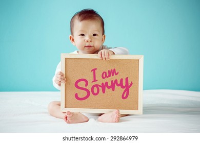 Baby writing "I am Sorry" on the board, new family concept, studio shot