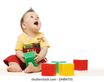 Baby in yellow shirt playing with bright blocks looking up in surprise - Shutterstock ID 19484755
