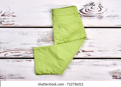 Baby-girl New Brand Trousers. Infant Girl Modern Pants Folded On White Wooden Background, Top View. Kids Fashion Garment.