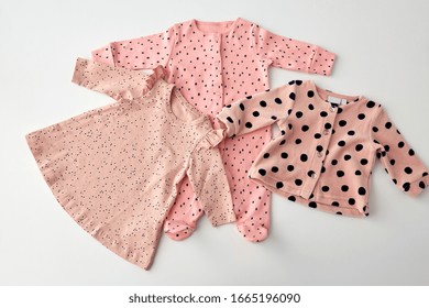 Babyhood And Clothing Concept - Pink Clothes For Baby Girl With Dot Print On White Background