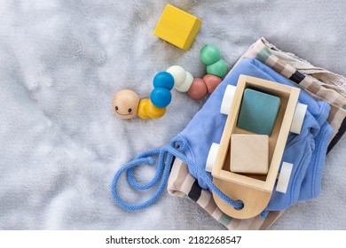 Baby,infant Clothes,wooden Train Wagon,cute Multi Colored Caterpillar,cubes Toys On Soft Grey Blanket.new Born Infant Clothing And Ecological Toys,donation Or Baby Shower.gift Box.it's A Boy