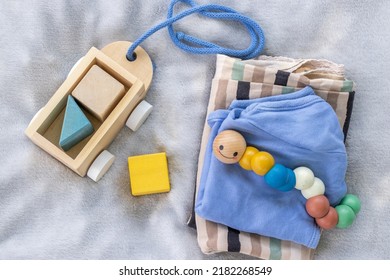 Baby,infant Clothes,wooden Train Wagon,cute Multi Colored Caterpillar,cubes Toys On Soft Grey Blanket.new Born Infant Clothing And Ecological Toys,donation Or Baby Shower.gift Box.it's A Boy