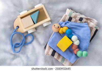 Baby,infant Clothes,wooden Train Wagon,cute Multi Colored Caterpillar,cubes Toys On Soft Grey Blanket.new Born Infant Clothing And Ecological Toys,donation Or Baby Shower.gift Box.it's A Boy