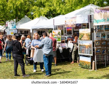 Babylon, New York, USA - 8 September 2019: People enjoying a sunny day walking around Argyle Lake and purchasing goods from vendors during the annual Babylon Beautification Society Fair.