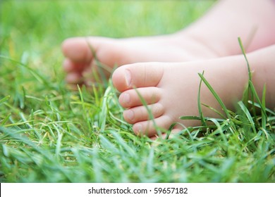 Baby`s Feet On Green Grass