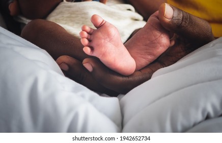 Baby's Foot Of African Black Skin Baby Newborn, Placed On The Father's Hand, Concept To Showing Love And Concern For His Children, And Is Love Family Relationship.