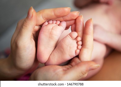 Baby's foot in mother hands closeup