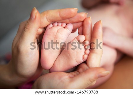 Baby's foot in mother hands closeup