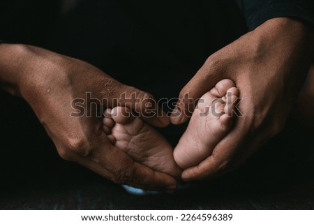 baby's foot in mother hands. natural light indoors, Instagram filter film effect
