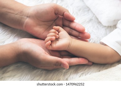 Baby's hand Placed on the mother's hand, concept to showing love and concern for her children, And is love family relationship.