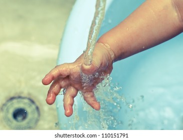 Baby's Hand Under A Water Stream