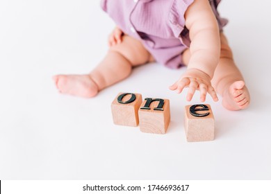 the baby's hands hold square letters. the word one is built from letters. the concept of leadership