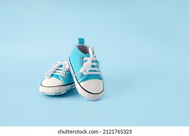 Baby's little blue sneakers on a colorful background. The concept of waiting for a baby and the concept of traveling with baby, children's lifestyle. Copy space, flat lay