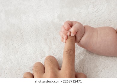 Baby's right hand grasping his father's finger (0 years and 2 months, boy, Japanese)