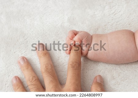 Baby's right hand grasping his father's finger (0 years and 2 months, boy, Japanese)