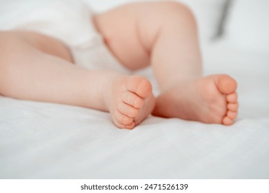 A baby's small foot on a white background of the bed, a newborn baby's heel. - Powered by Shutterstock