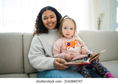 A babysitter black woman read book with little child girl