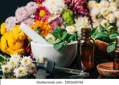 Bach Flower Remedies - Alternative Herbal Medicine. Dropper Bottles, Flowers, And Mortar And Pestle Full Of Fresh Mint 