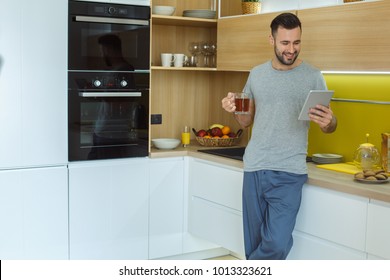 Bachelor Man Daily Routine In A Kitchen Single Lifestyle Concept Drinking Hot Tea Using Digital Tablet