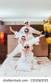 Bachelorette Party Joy And Fun. Balloons Decor. Row Of Posing Smiling Women In Sunglasses, Bathrobes And Towel Turbans.