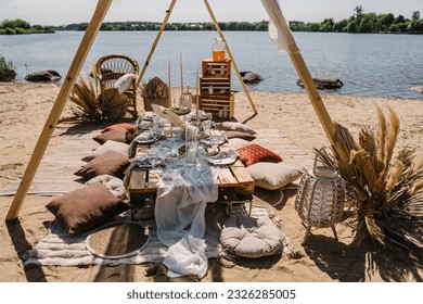 Bachelorette party on beach. Boho style design picnic. Decorations for celebration birthday. Lunch in romantic colors. Summer spring picnic with blanket, pillows, candles, wooden decor, dry flowers. - Powered by Shutterstock