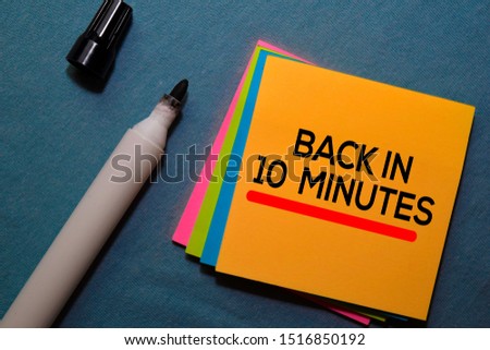 Back in 10 Minutes on sticky notes isolated on Office Desk