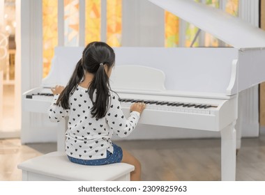 back asian child cute or kid girl musician and happy playing white piano or vintage electone to song show on stage or people learning at music school for artist education and instrumental music study - Powered by Shutterstock