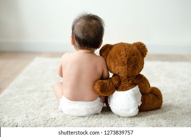 Back of a baby with a teddy bear