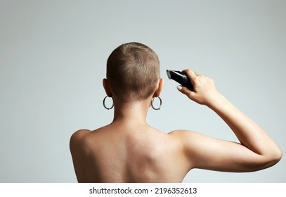 Back Of Bald Woman With Hairclipper And Earrings. Beauty Portrait Of Short Haircut Girl