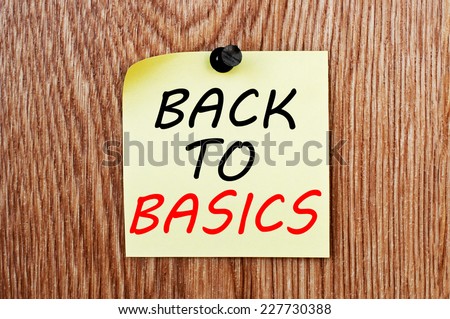 Back to Basics written on a note paper with a wood wall on a background