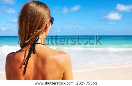 Back of beautiful girl in bikini  on tropical beach