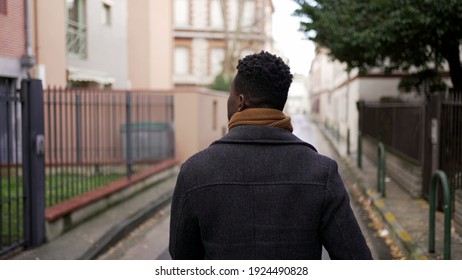 Back of black African man walking outside in urban city