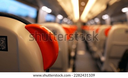 Back of blurry train perspective in motion. Passenger seats in highspeed transportation corridor