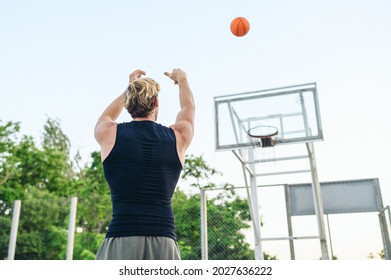 Back Bottom View Young Sporty Muscular Strong Sportsman Man 20s Wearing Sports Clothes Training Shooting Free Throw Play With Ball At Basketball Game Playground Court Outdoor Courtyard Sport Concept.