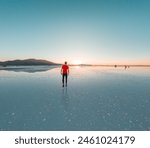 Back of a boy at Uyuni salt flats during sunset with reflection