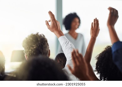 Back, business people and hands raised for questions at conference, seminar or meeting. Group, audience and hand up for question, asking or answer, crowd vote and training at workshop presentation.