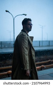 Back Of Cinematic Young Man In Winter Coat Walking Outside In Urban City On Bridge On A Moody, Foggy, Winters Night.