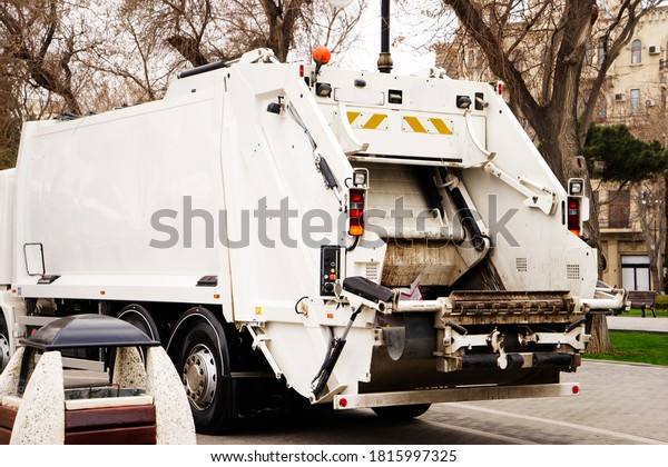 Back\
of a city garbage truck with waste already\
inside.