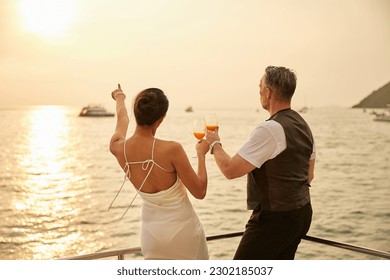 back couple drinking orange juice in luxury yacht - Powered by Shutterstock