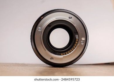 Back of Digital Camera Lens with Perfect Lighting on Wood Floor Against White Background