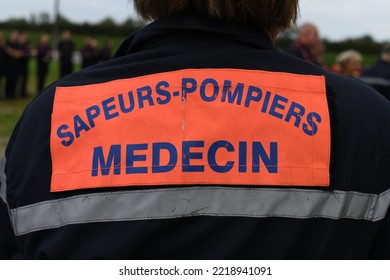 Back Of A Doctor Specialized In Emergency Situations Such As Natural Disasters. Equipped With A High Visibility Jacket For Quick Identification Of Each Member Of The Intervention Team. 