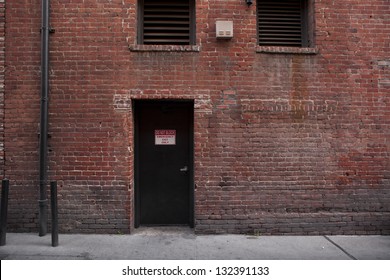 Back Door Entrance To An Old Brick Building From The Alley.