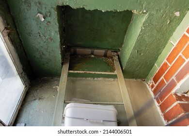 Back Door On The Balcony. A Fire Escape In A High-rise Building On A Balcony With A Closed Hatch. Fire Safety.