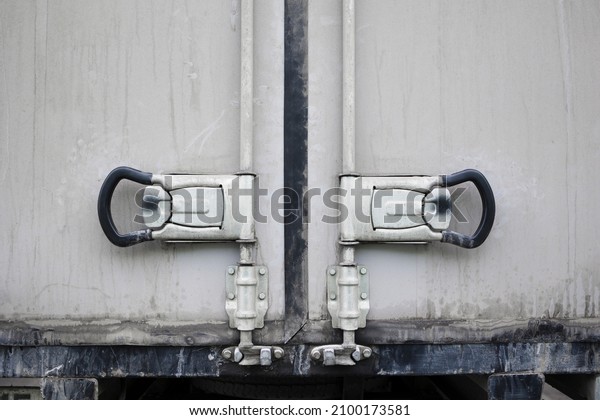 Back doors of white dirty cargo truck . Close\
up Handle and lock of Cargo\
Truck