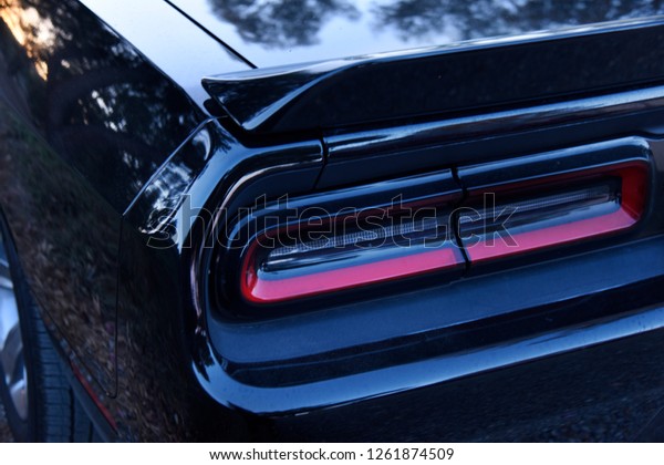 Back end of a shiny black\
sports car