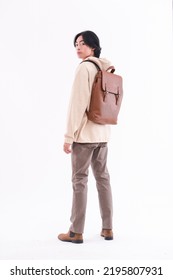 Back Full Body Portrait Of Young Man Wearing Hoodie With Brown Jeans With Backpack Posing On White Background,