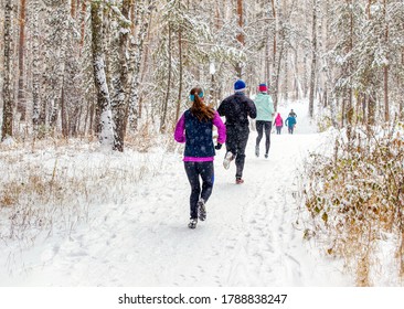 Back Group Runners Run Winter Trail Race In Forest During A Snowfall